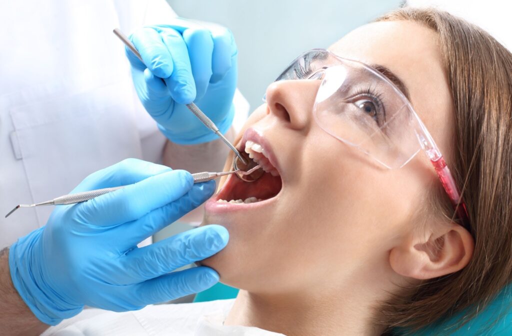 A close up of a dental patient having their teeth scaled