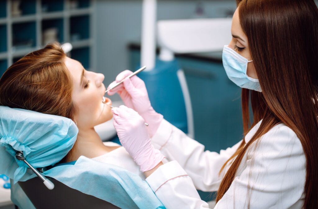 A dental hygienist performing a dental cleaning on a patient to remove the build up of dental plaque.