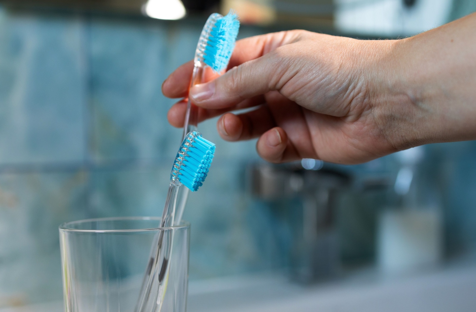 A person reaching for their tooth brush, to carefully and gently brush their teeth and wisdom teeth removal.
