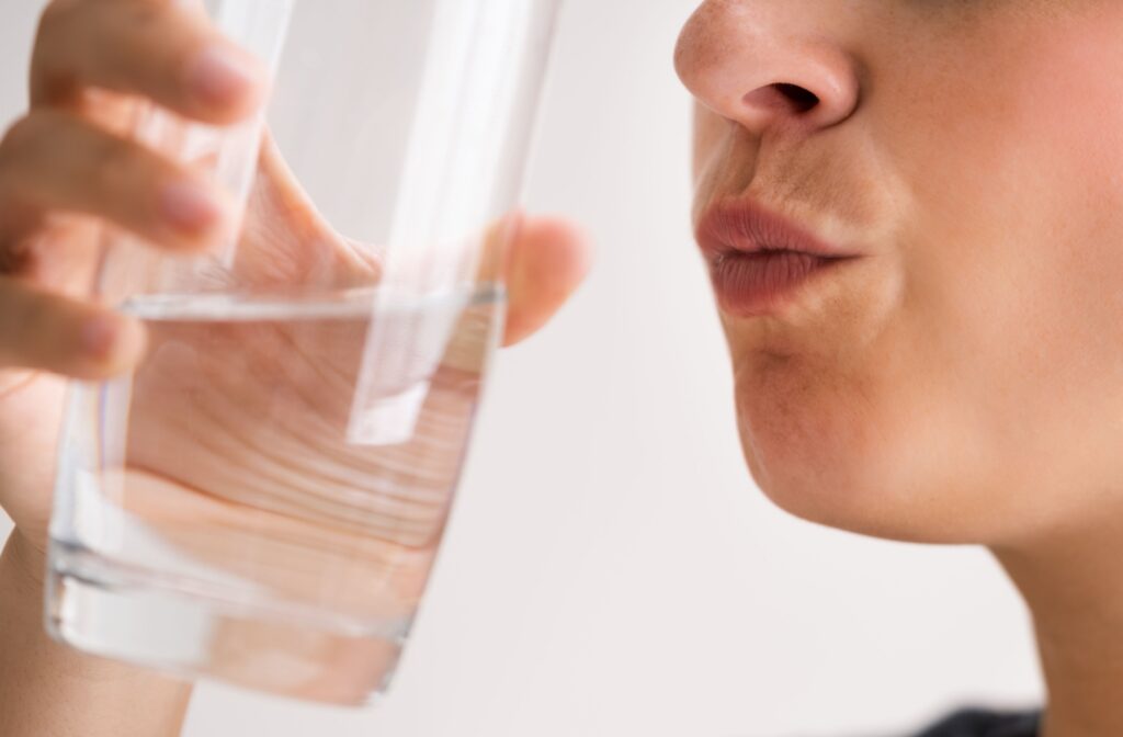 A person rinsing their month with a saltwater rinse after wisdom teeth removal.